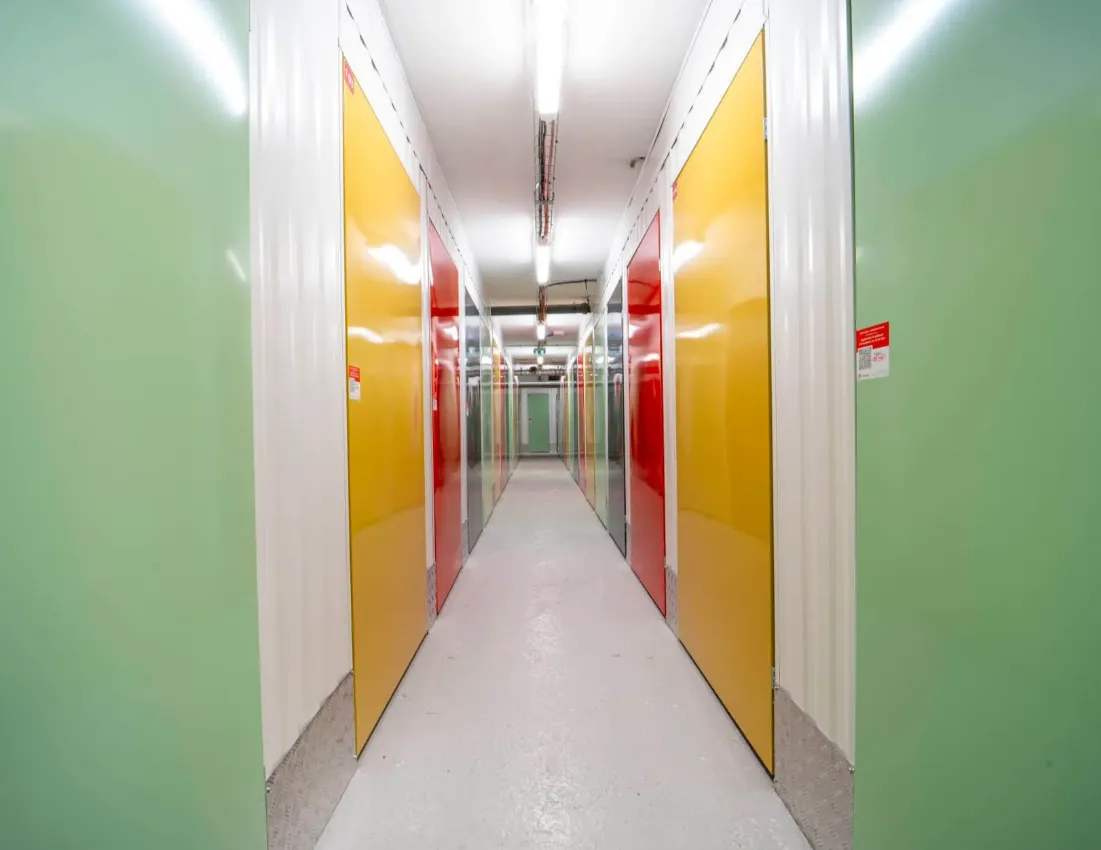 Allée du centre du Bignon, grandes portes jaunes et rouges sur murs vert d'eau.