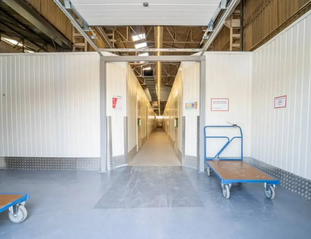 Hall du centre de Saint-Brieuc Pommeret, un chariot de manutention devant l'allée de box.